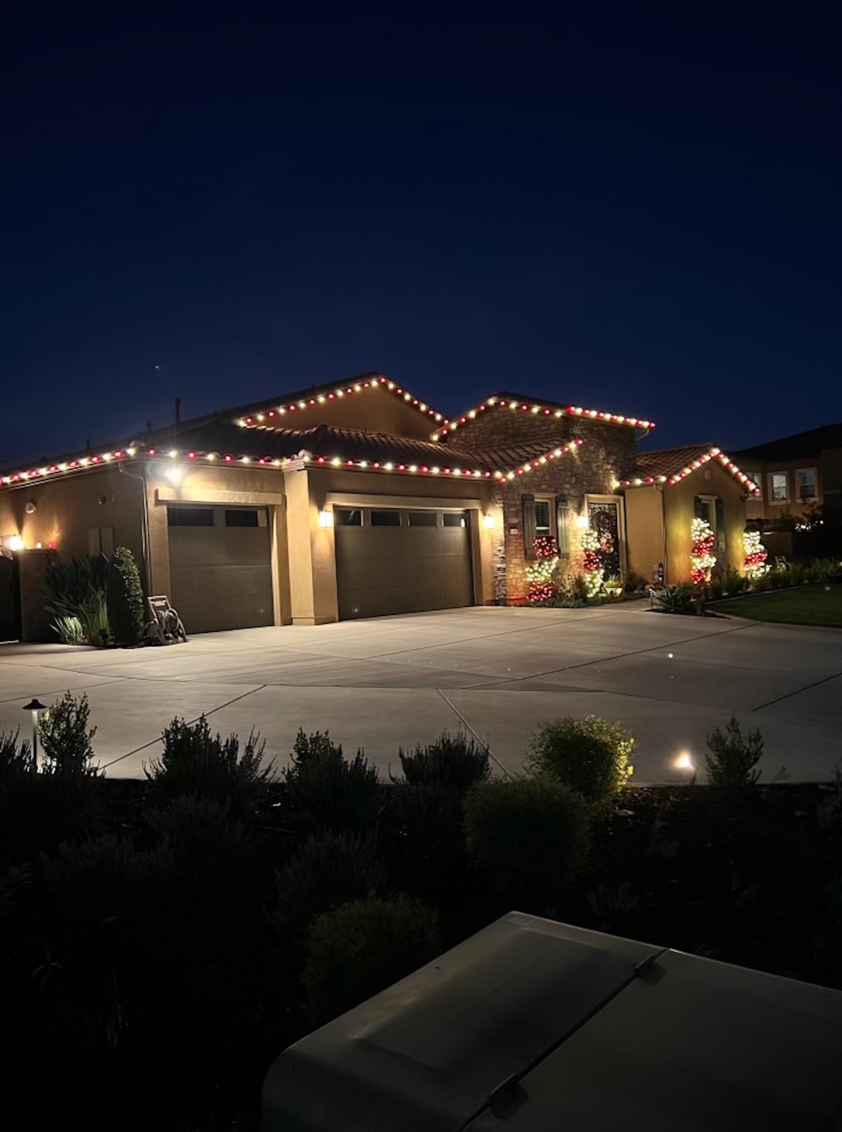 Red and white roofline on a stone-accent home at twilight