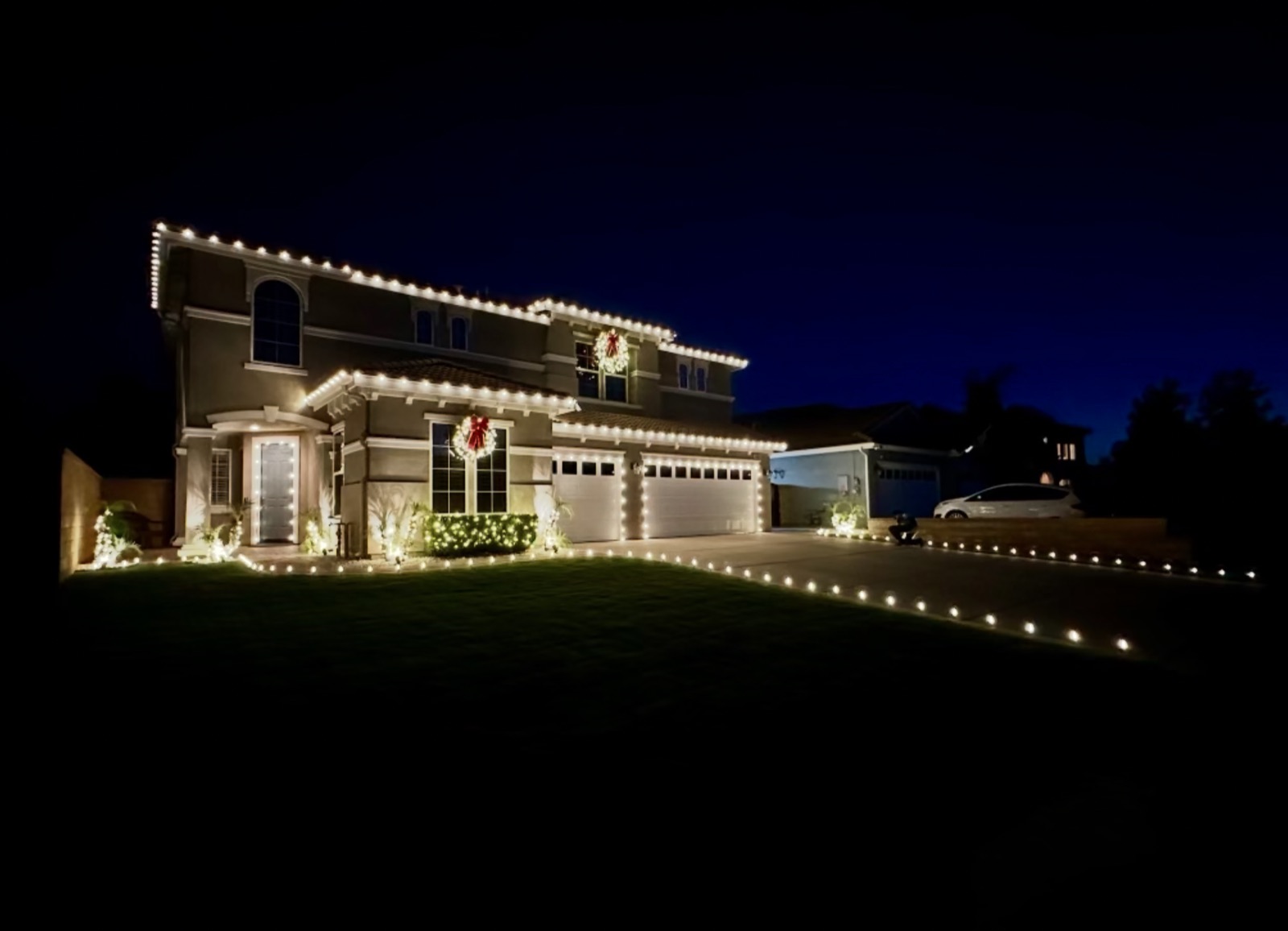 Warm-white two-story roofline with wreaths
