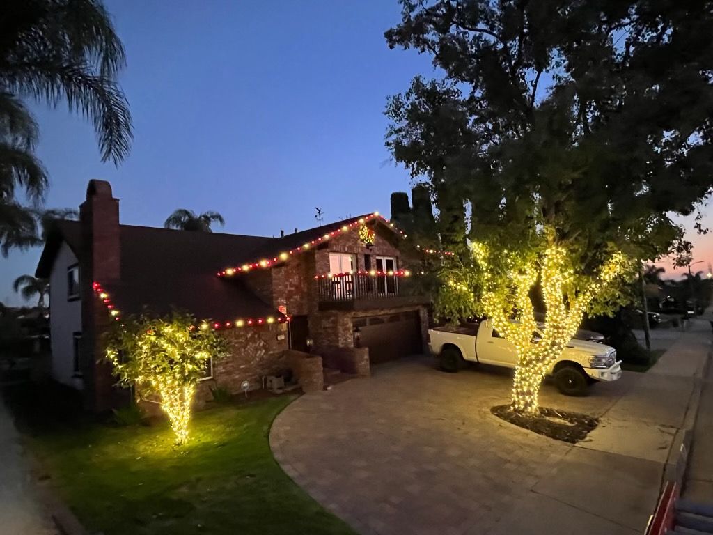 Twilight roofline and glowing tree wraps installed by Hanson Holiday Lighting